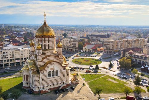 Aerial drone view of the Fagaras, Romania. Church of the Saint John the Baptist, buildings, roads with cars, greenery